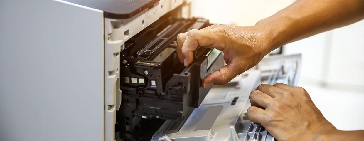 hands working on the back of multifunction copier