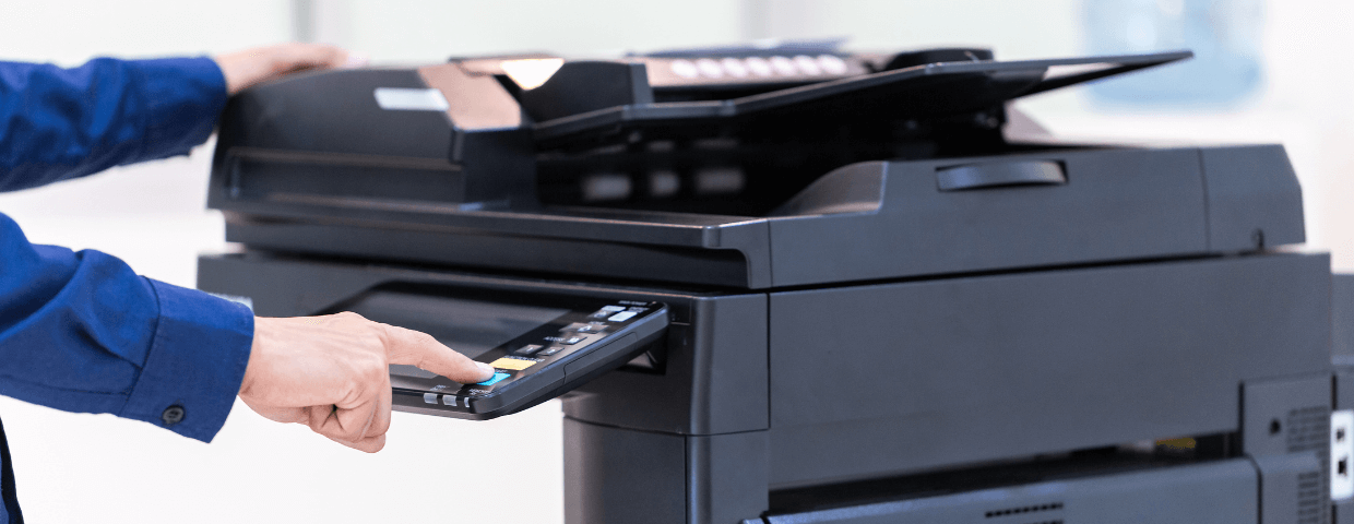 Business man pushing buttons on large multifunction printer
